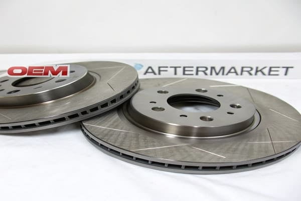 an OEM brake rotor next to an aftermarket performance rotor