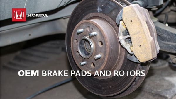 A set of Honda OEM brake pads and rotors neatly arranged