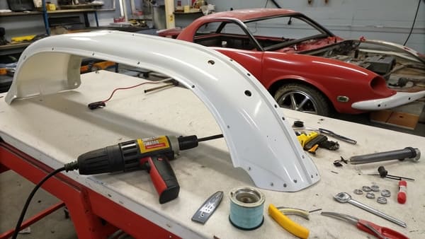 A person using a heat gun to repair a plastic car part