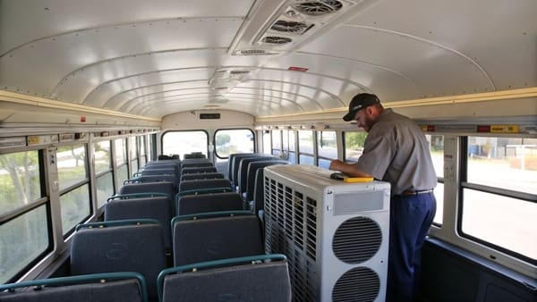 A modern school bus with a rooftop air conditioning unit