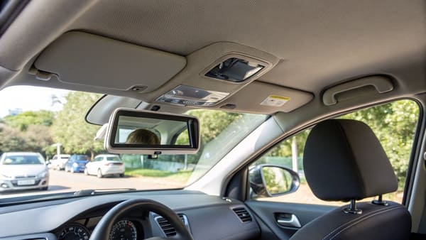 A close-up of a car's sun visor mirror with a light