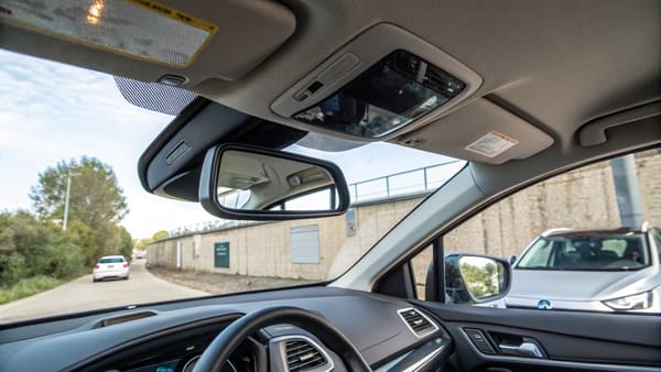 A driver's view through the rearview mirror, showing traffic behind the car.