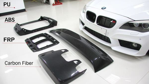 A side-by-side comparison of a plastic bumper and a carbon fiber spoiler