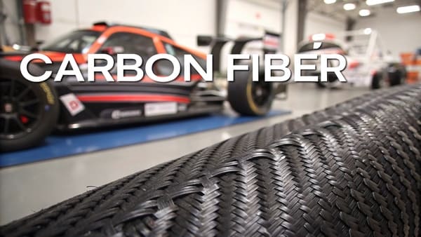a worker applying resin to carbon fiber fabric in a mold