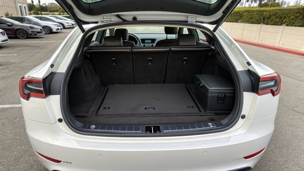 The front trunk (frunk) of a Tesla Model 3 with a backpack inside