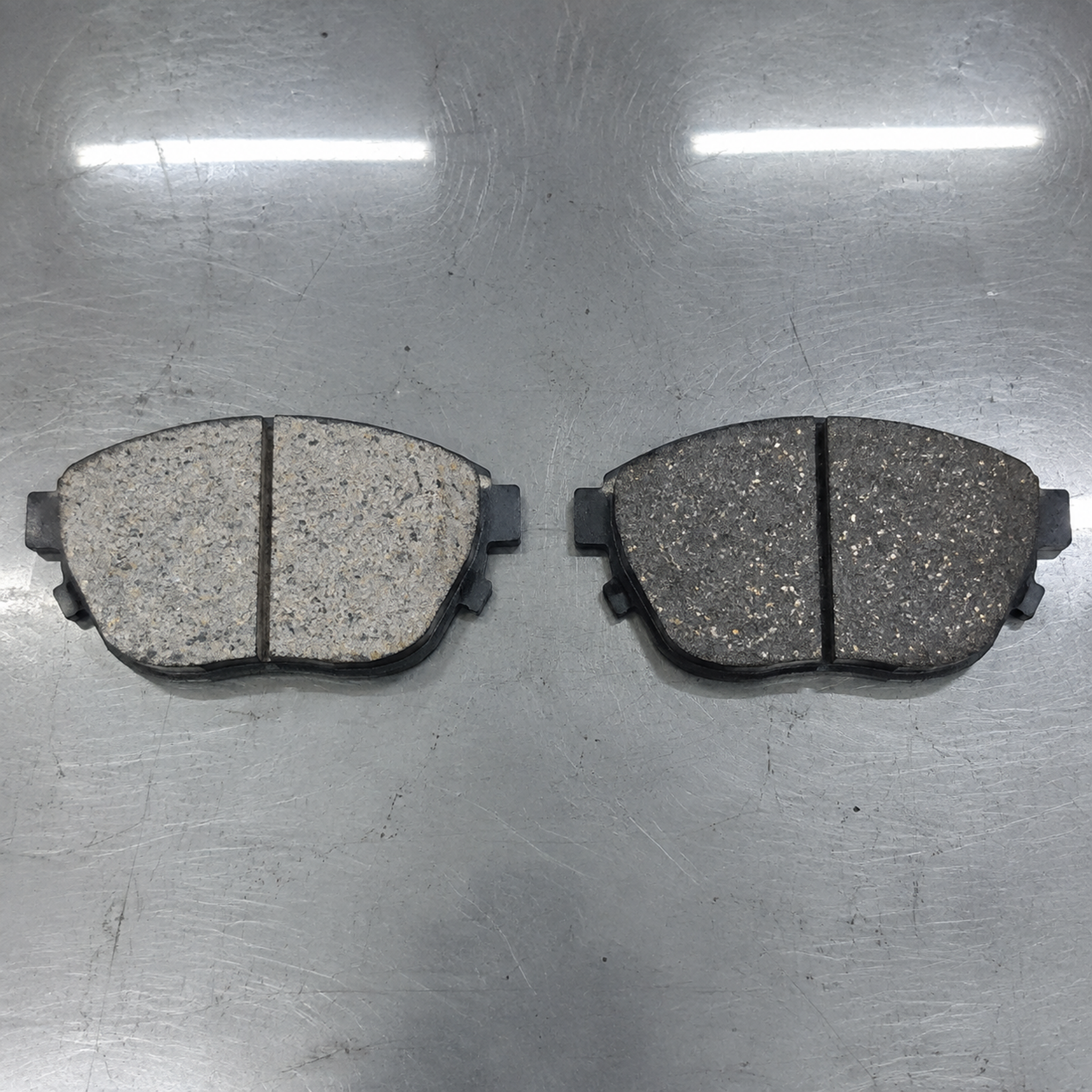 Ceramic vs semi-metallic brake pads comparison Ceramic vs semi-metallic brake pads compared on a factory inspection bench